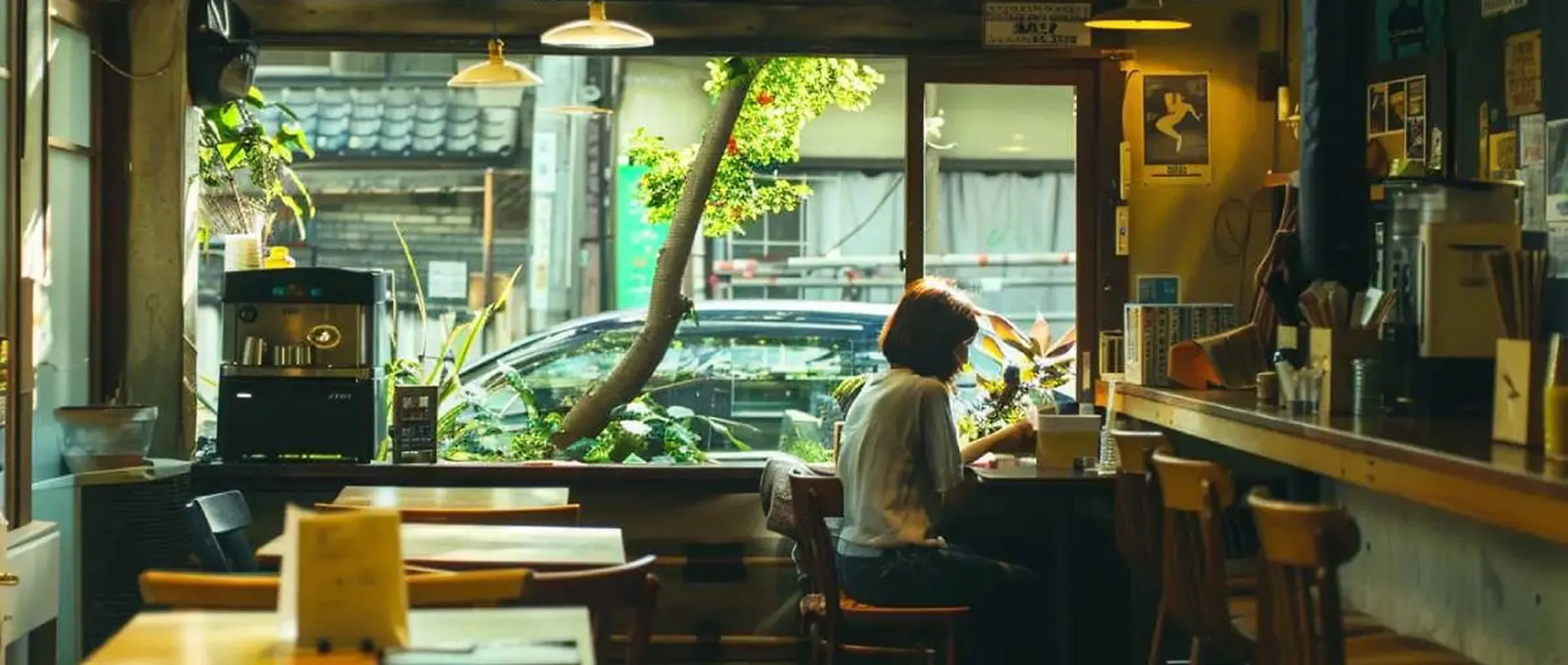Modern cafe interior with large windows overlooking greenery
